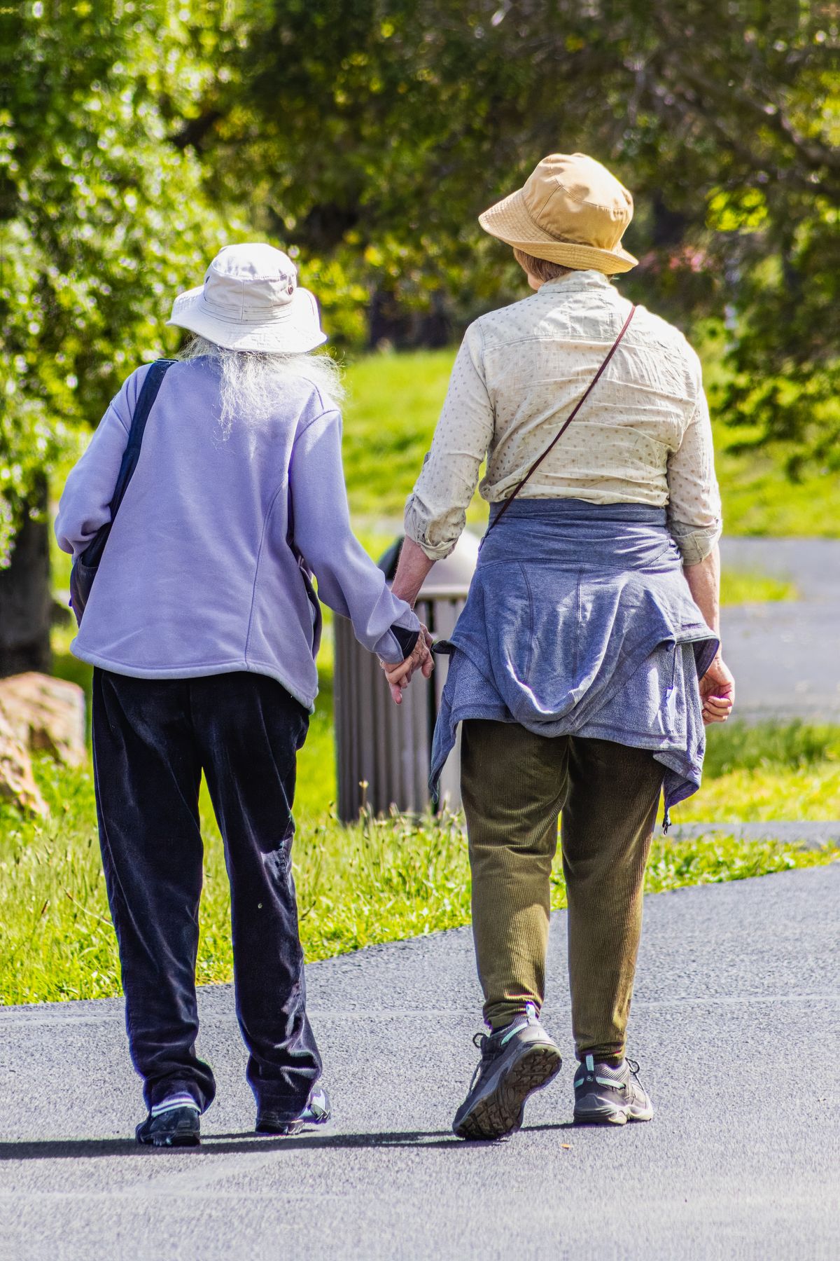 Two women over 55 walking briskly together in a park