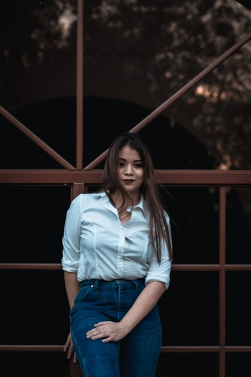 Woman In White Dress Shirt And Blue Jeans 