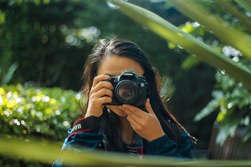 無料 デジタル一眼レフカメラを使用している女性 写真素材