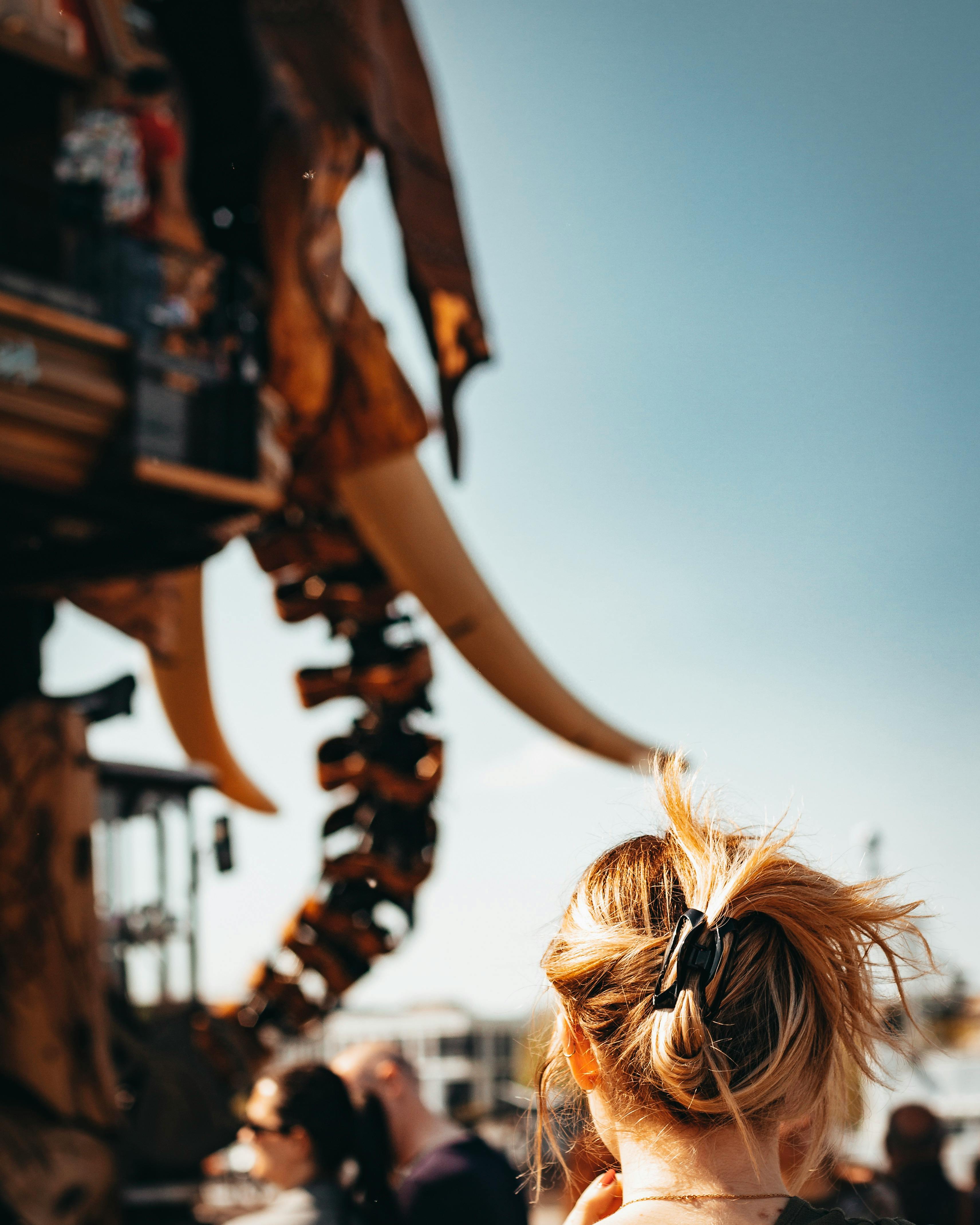 节日期间，一位留着时髦头发的女人在户外观察一只大型机械大象