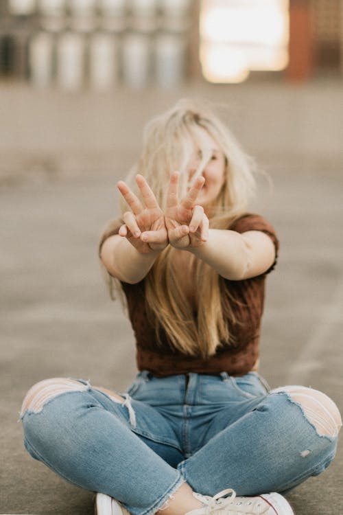 Blonde Woman Sitting and Showing Gesture