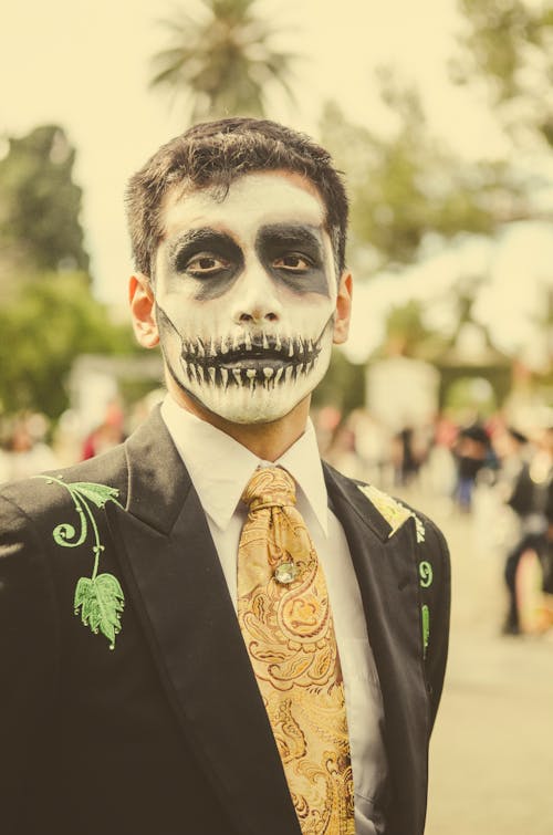 A man with a face painted in a skeleton costume