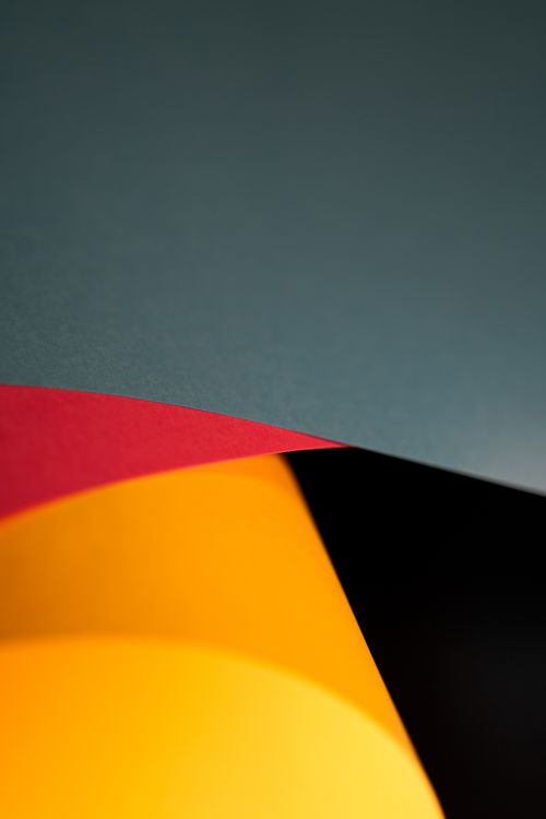 Free A vibrant abstract image of layered colored papers creating geometric shapes and contrasts. Stock Photo