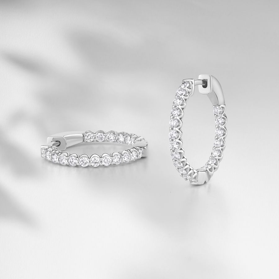 Diamond earrings on a minimalist white surface