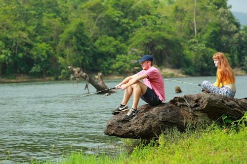 Young Couple with Fishing Rods by River in Summer