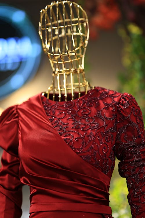 A mannequin wearing a red dress with a gold headpiece