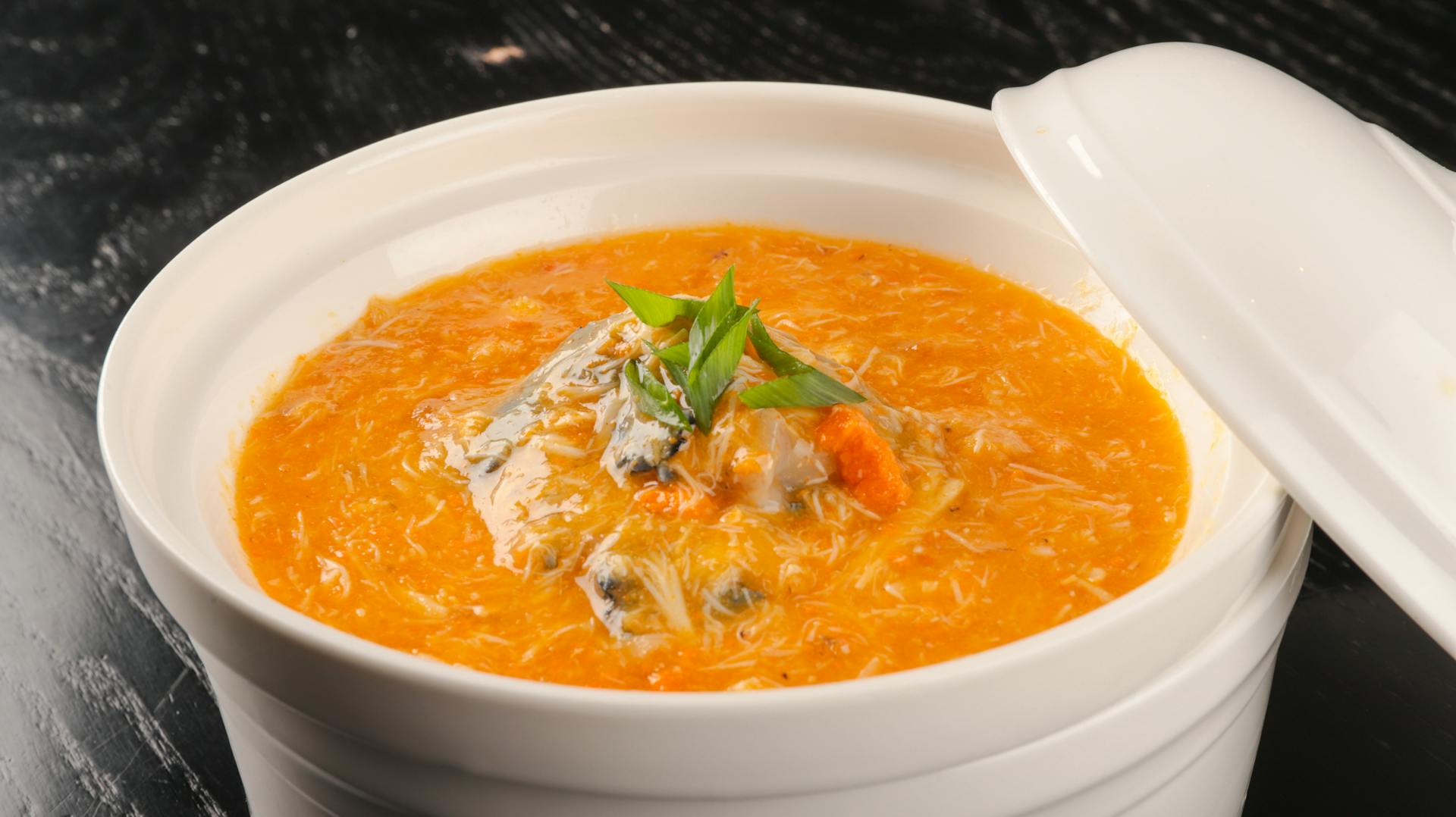 A savory pumpkin soup garnished with herbs, perfect for a cozy meal.