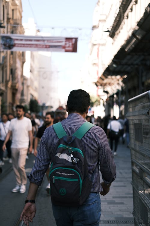 A man walking down a city street with a backpack