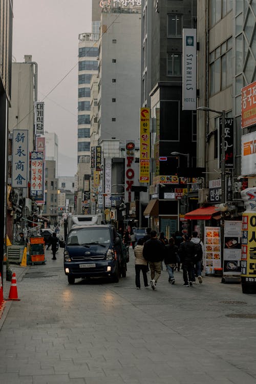 A city street with people walking and cars driving