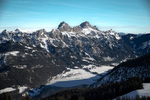 A view of a snowy mountain range with a lake