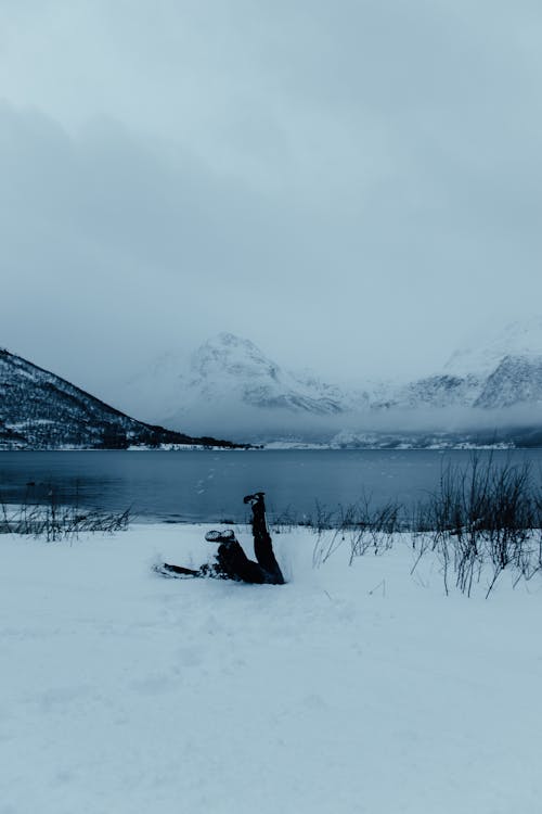 A person laying on the snow in the middle of a lake