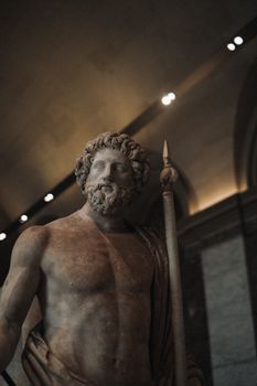 Majestic marble statue of Zeus displayed at the Louvre Museum in Paris.