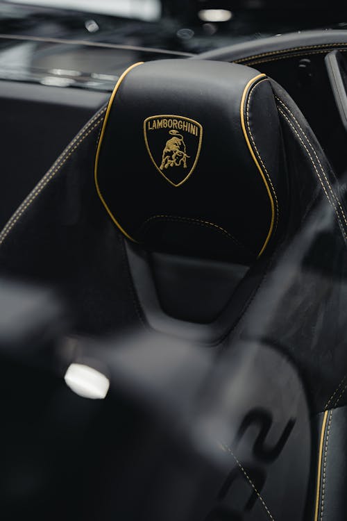 The interior of a black lamborghini with a gold logo