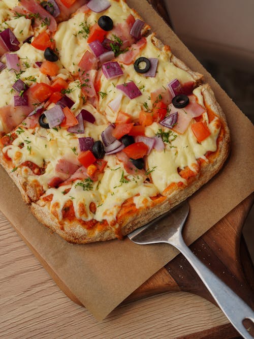 A pizza with toppings on it sitting on a cutting board