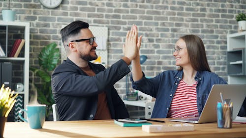 Two people giving high five to each other in an office