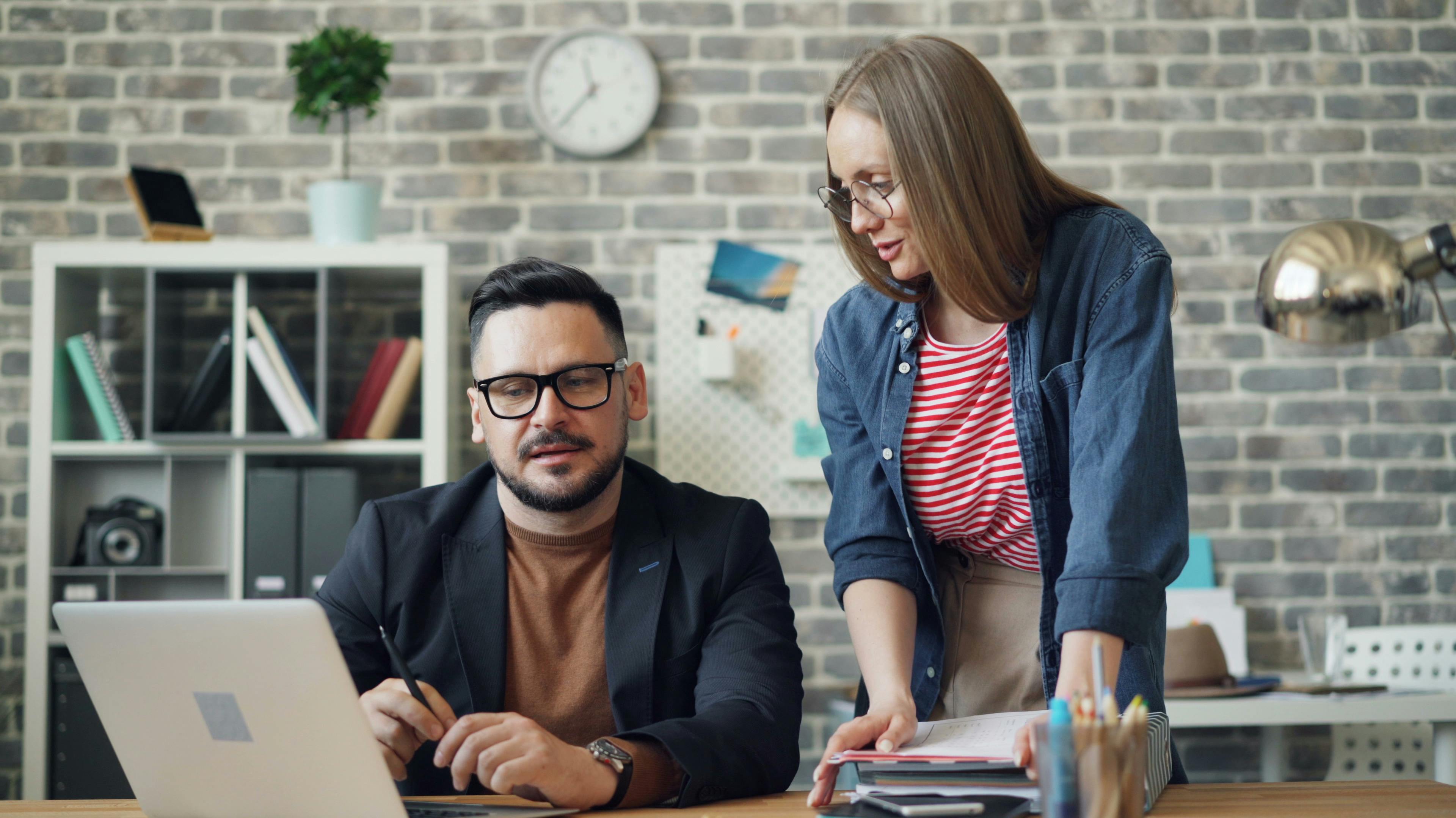 A Man and a Woman Talking in a Modern Office · Free Stock Photo