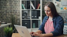 Worried Woman Writing on Laptop at in Office