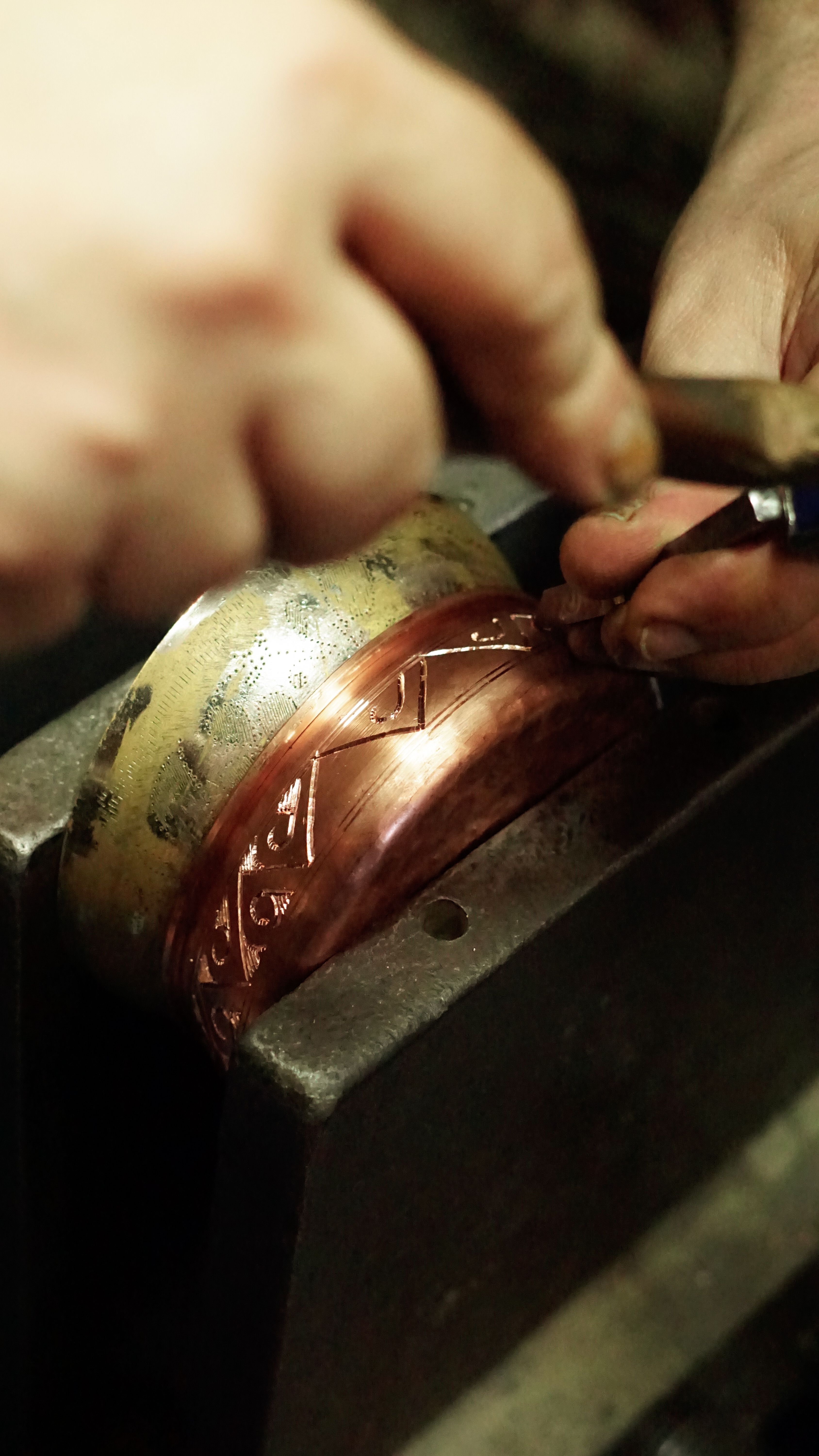 Close-up of skilled artisan precision crafting intricate metal design.
