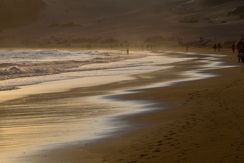 Serene dusk scenery at Bolonia Beach, Andalusia, capturing waves and distant silhouettes.