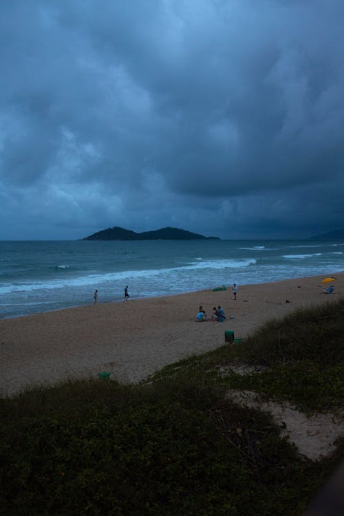 A Stormy Beach Against a Landscape with an Island Background