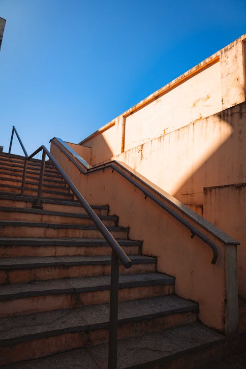 A stairway with metal railing and a blue sky