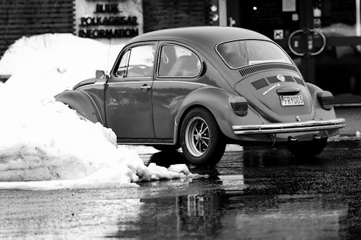 Black and white photo of a classic Volkswagen Beetle in a snowy street in Jönköping, Sweden.