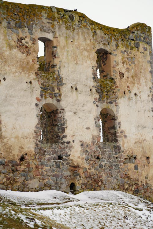 A man is standing in front of an old building