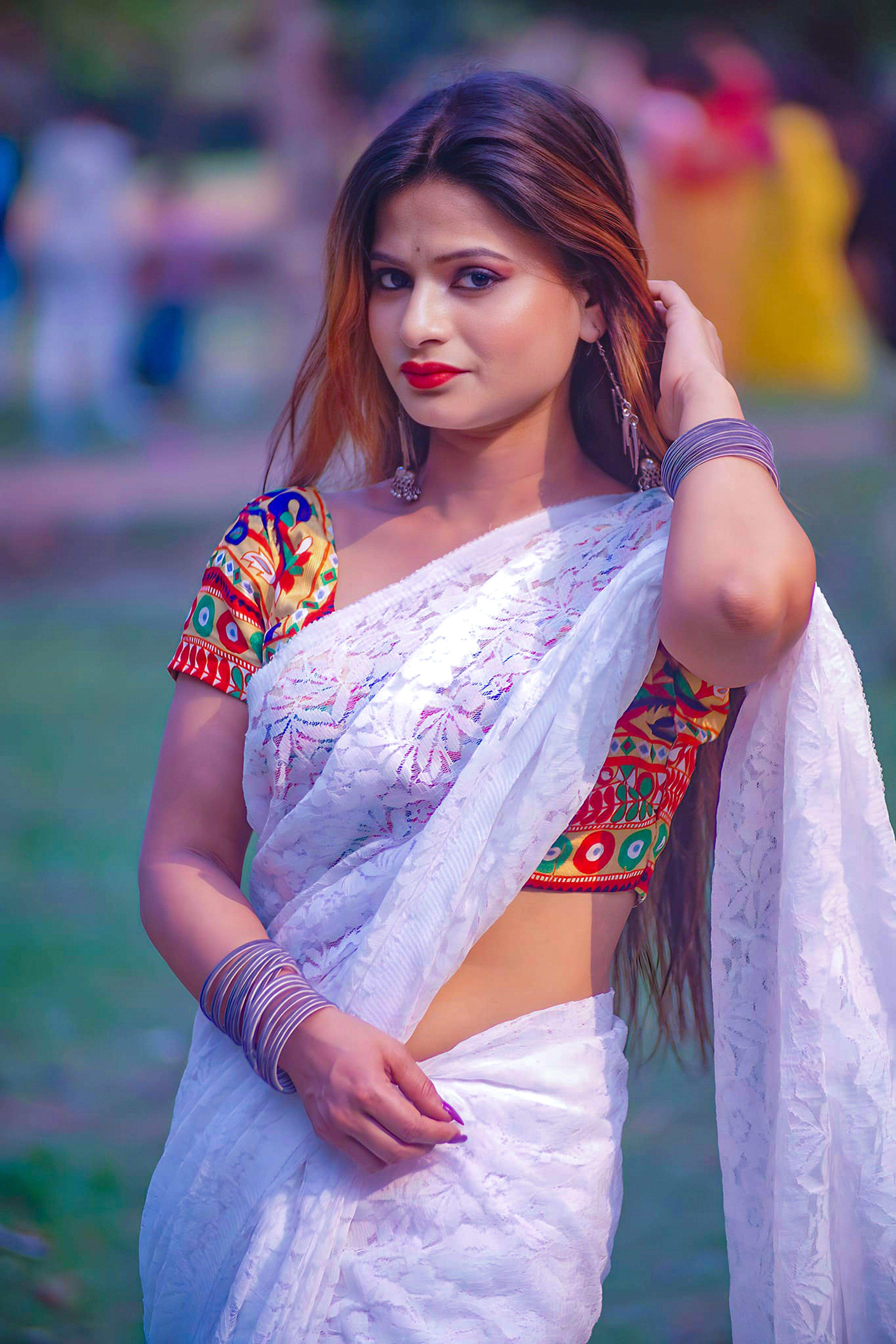 Portrait of an Indian woman in a colorful saree posing outdoors.