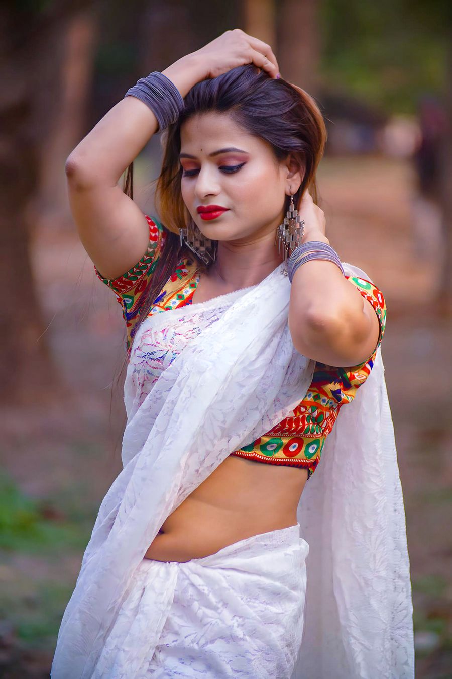 Woman wearing a white chikankari saree with a contrast embroidered blouse