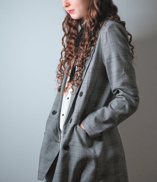 A woman with long curly hair and a plaid jacket