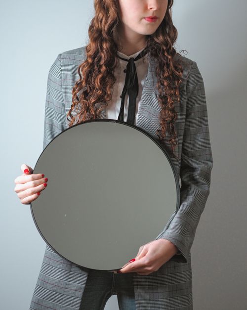Free Stylish woman in Paris holding a round mirror, capturing elegance and modern fashion. Stock Photo