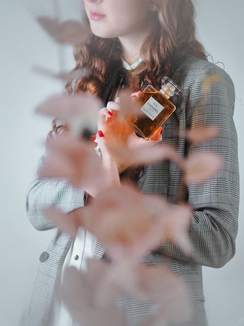 A woman holding a perfume bottle in her hand