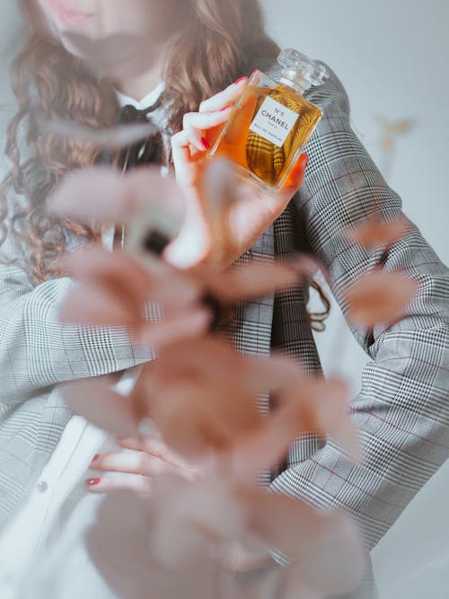 A woman holding a perfume bottle in front of her