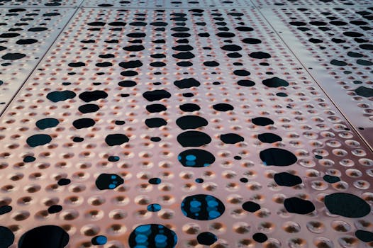 Abstract close-up of a perforated metal surface with geometric patterns and texture.