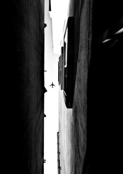 飞机掠过狭窄的城市景观，飞过对比鲜明的建筑物