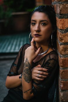 在圣保罗，一名纹身女子倚着砖墙摆出沉思的姿势