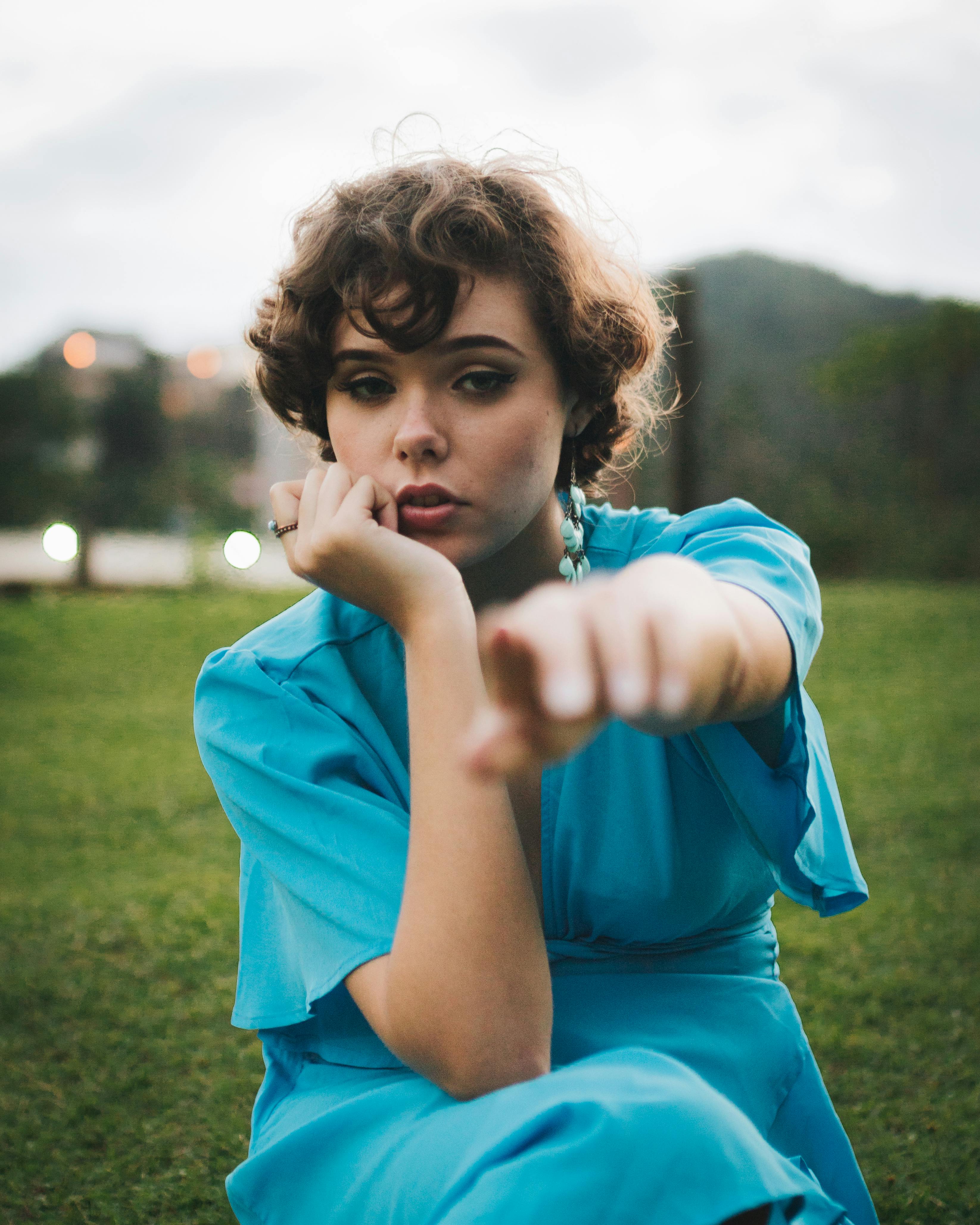 一位身着亮蓝色礼服的女人，在户外以模糊的自然为背景拍摄时尚肖像