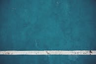 特写视图中，蓝色墙壁的纹理与风化白线，是完美的抽象图案或背景素材