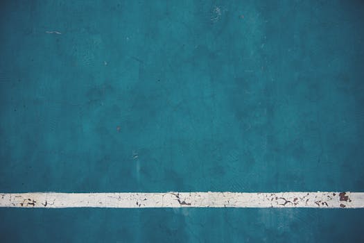特写视图中，蓝色墙壁的纹理与风化白线，是完美的抽象图案或背景素材