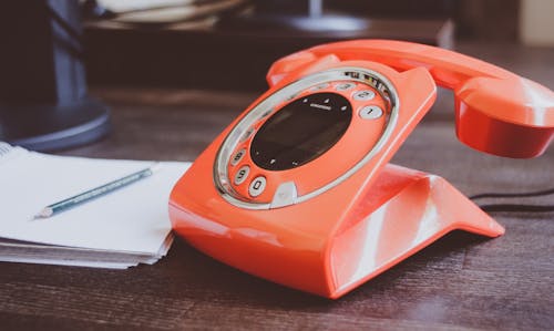 Free Red Cradle Telephone on Brown Wooden Surface Stock Photo