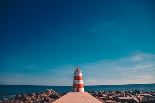 Orange and White Lighthouse on Dock