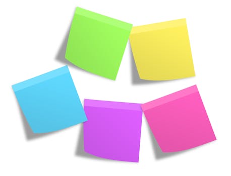 Pink Green Yellow Blue and Purple Sticky Note Mounted on White Painted Wall