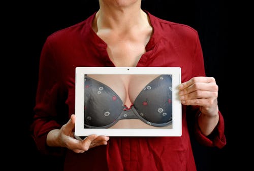 Free Woman Holding White Tablet Computer Showing Gray Bra Stock Photo