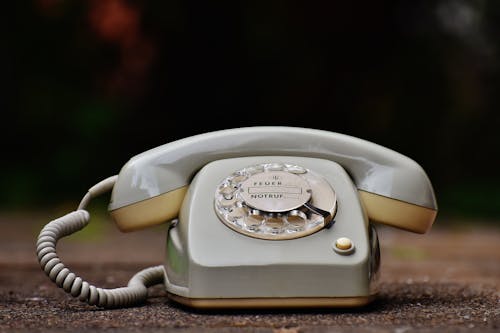 Free Gray Rotary Telephone on Brown Surface Stock Photo
