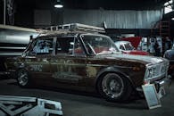 经典复古轿车在工业仓库环境中展示，尽显复古魅力