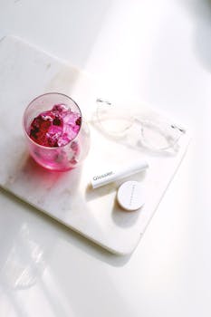 平放在大理石上的粉红色饮料化妆品，非常适合美容和生活方式主题