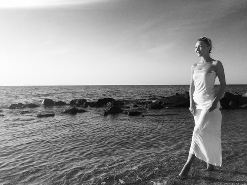 Free A serene moment captured in black and white as a woman walks by the sea in Ukraine. Stock Photo
