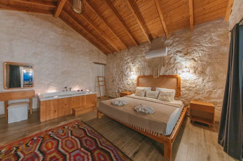 Free A bedroom with a bed and a stone wall Stock Photo