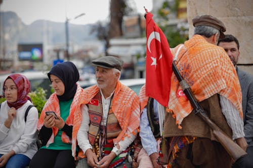 A group of people standing on a street with flags