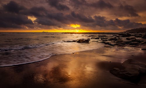 Sunset in Cloudy Sky over Seashore